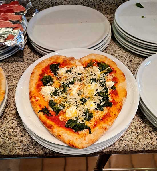 Foto einer Pizza mit Parmaschinken, Parmesan, Kirschtomaten und Mozzarella